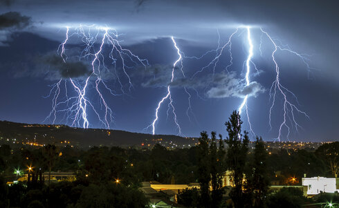 Langzeitbelichtung Gewitter bei Nacht über ländlicher Gegend, hügelig